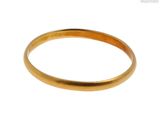 gros plan d'une bague en or sur fond blanc