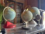 three globes sitting on top of a table in a room