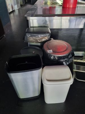 many trash cans sitting on the floor next to each other
