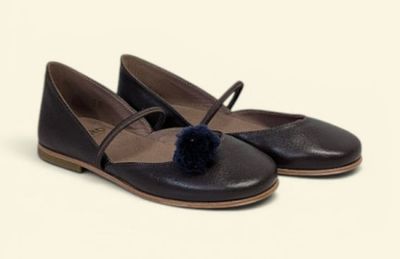 the shoes are brown and black with a pom pom on the toe