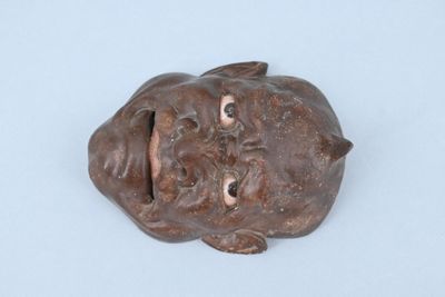 une petite statue représentant un chien couché par terre