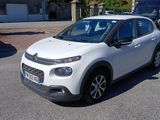 une petite voiture blanche garée dans un parking