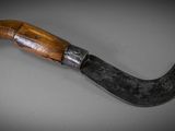 a close up of a knife with a wooden handle on a table