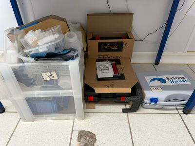 a pile of boxes sitting on the floor next to a trash can
