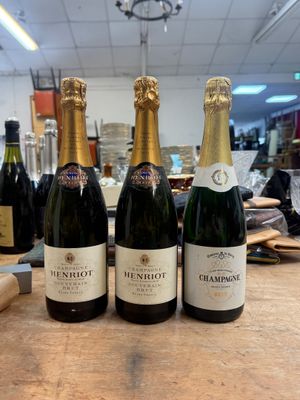 trois bouteilles de champagne sont alignées sur une table