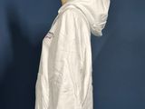 a white jacket on a mannequin stand against a blue wall