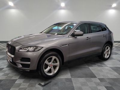 Un SUV Jaguar gris est garé dans un garage.