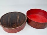 two red bowls are sitting on a white surface next to each other