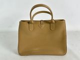 a tan leather handbag on a white background