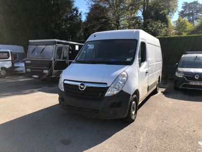 une camionnette blanche garée dans un parking à côté d'autres voitures