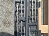 a lot of drill bits in a case on the ground