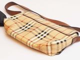 a small purse with a brown strap on a white surface