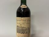une vieille bouteille de vin posée sur une table blanche