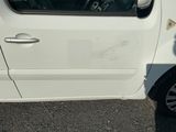 une petite voiture blanche garée sur le bord de la route