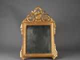 un cadre doré richement décoré, avec un miroir au centre