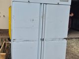 a white refrigerator sitting outside of a building next to a building