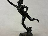 statue of a man holding a frisbee in his right hand