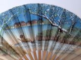 a fan with a painting of a boat on the water