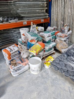 many bags of cement sitting on the floor in a warehouse