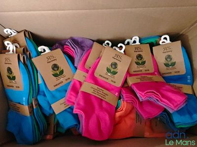 several pairs of socks in a cardboard box with tags on them