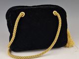un sac à main en velours noir muni d'une anse en corde dorée