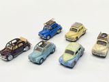 plusieurs petites voitures sont alignées sur une surface blanche