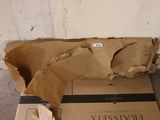 une boîte en carton posée par terre à côté d'une autre boîte en carton