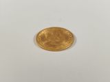 a close up of a gold coin on a white surface