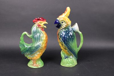 pair of colorful ceramic figurines of roosters on a black background