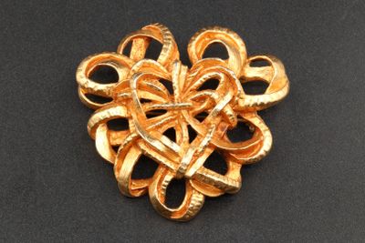 an image of a gold plated brooch with a knot in the center