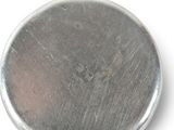 a close up of a metal button on a white surface