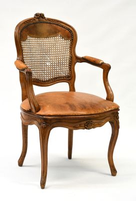 une image représentant une chaise en bois avec une assise en cuir marron