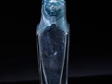 an image of a glass bottle with a statue on top of it