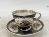 a tea cup and saucer on a white table