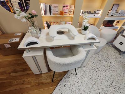 un bureau blanc sur lequel se trouve un téléphone, dans une pièce