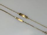 two gold bracelets on a white surface with a chain