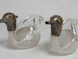 two glass ducks sitting next to each other on a table