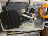 a plastic container with a camera and other items in it