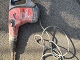 a cord and a drill on the ground next to a pair of shoes