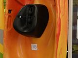 Des kayaks aux couleurs vives sont exposés dans un vaste espace intérieur