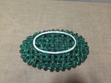 a picture of a green brooch with a white ring