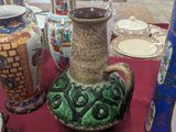 many different vases on a table with a red table cloth