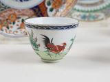 a small bowl with a rooster on it and a plate with a bird on it