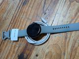 une montre connectée branchée sur un chargeur posé sur une table