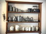 une étagère en bois sur laquelle sont disposés de nombreux types de casseroles et de poêles