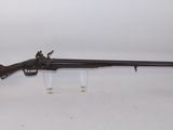 a rifle with a wooden barrel on a white surface