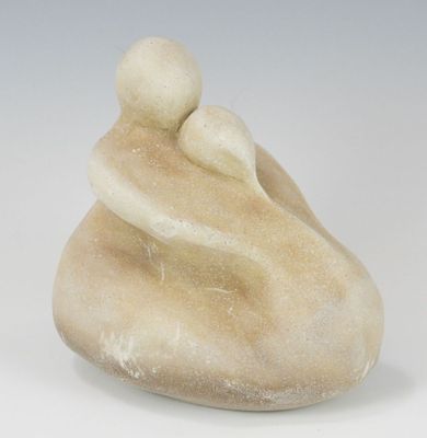 une sculpture représentant une mère et son enfant assis sur un rocher