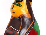 brightly colored cat figurine sitting on white surface with white background