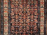 an antique persian rug with a floral design on a black ground