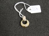 un collier en argent et en or auquel est accrochée une médaille